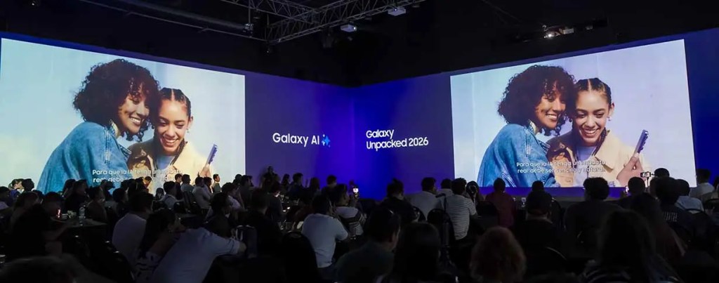 Evento de presentación de Galaxy Unpacked 2026 con dos mujeres sonriendo en la pantalla y una audiencia sentada frente a ellas.