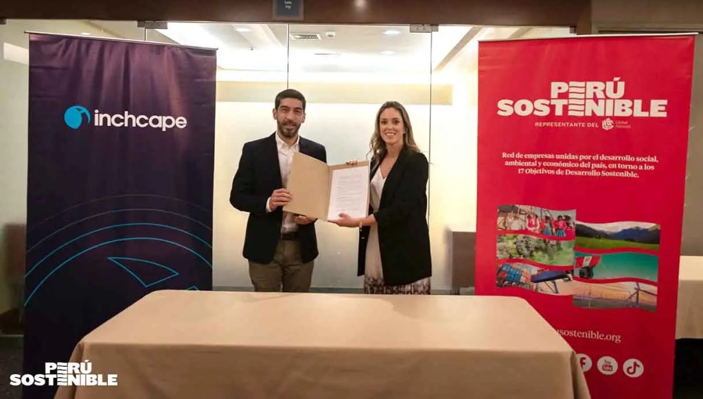 Dos personas sosteniendo un documento frente a un banner de Inchcape y otro de Perú Sostenible en un evento formal.