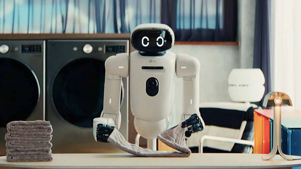 Robot asistente en una lavandería, sosteniendo una toalla doblada, con lavadoras en el fondo.