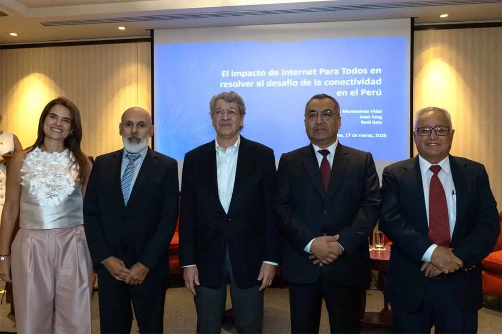 Grupo de personas posando frente a una pantalla que muestra un presentación sobre el impacto de Internet en la conectividad en Perú.