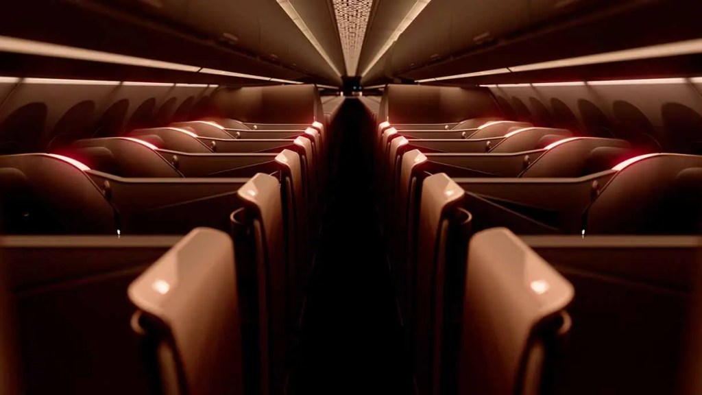 Interior de un avión con filas de asientos iluminados suavemente en tonos cálidos.