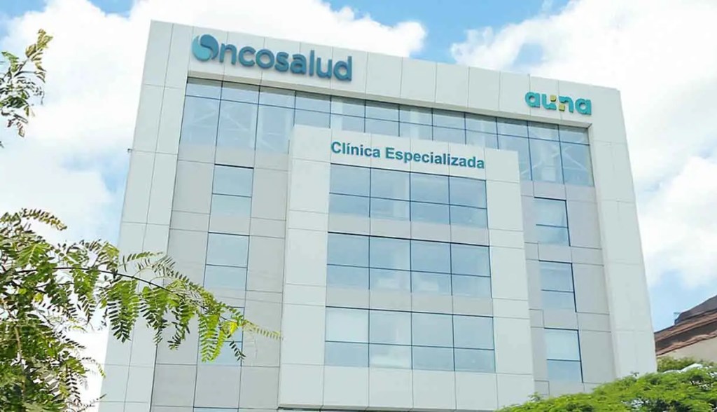 Edificio de la clínica Oncosalud, especializado en atención médica, con ventanales y cielo azul.