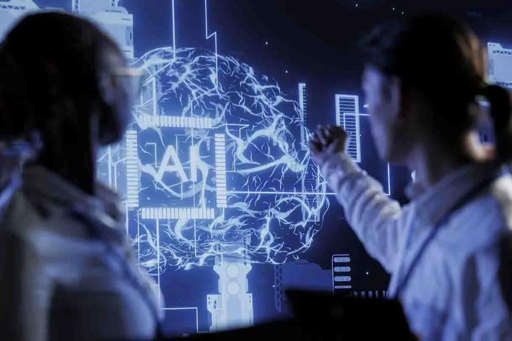 Dos personas observan una pantalla con gráficos de inteligencia artificial y un cerebro iluminado en azul.
