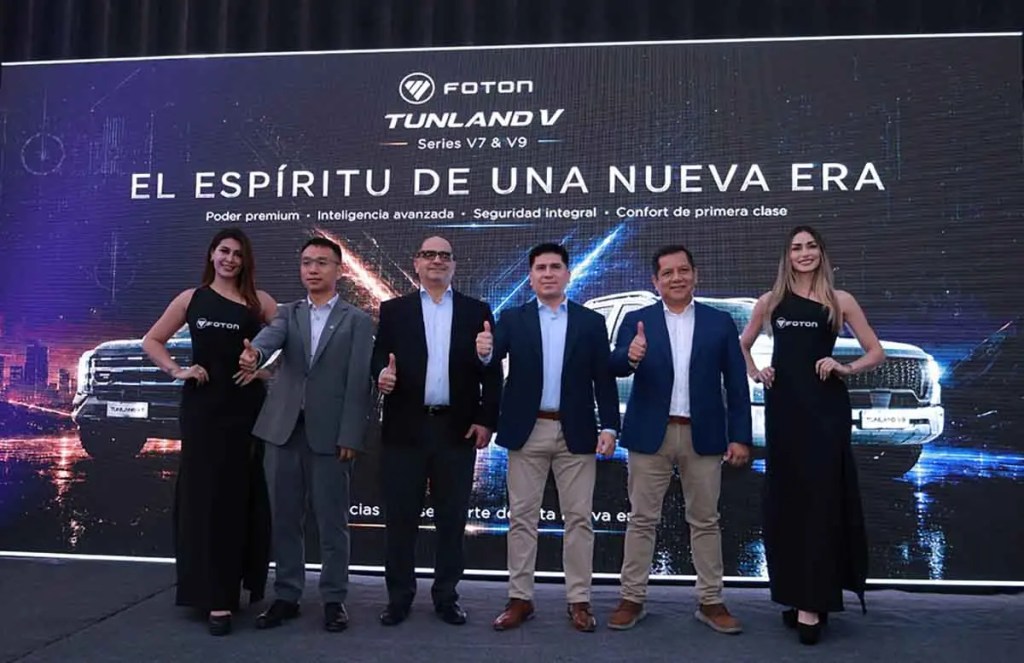 Evento de lanzamiento de la camioneta Foton Tunland V con presentadores y el logotipo de la marca en el fondo.