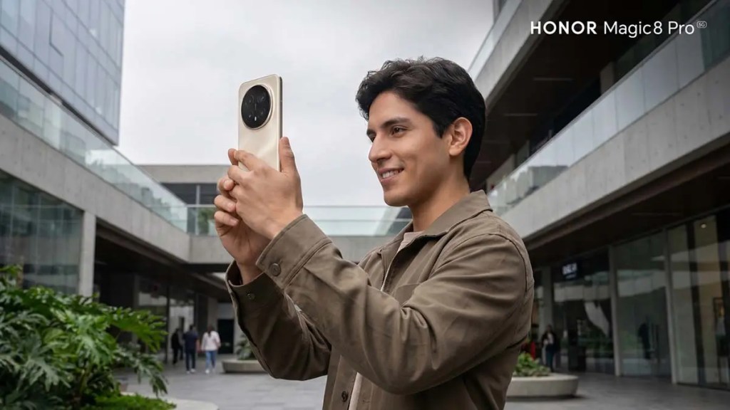 Joven sosteniendo un teléfono inteligente HONOR Magic8 Pro y sonriendo en un entorno urbano moderno.