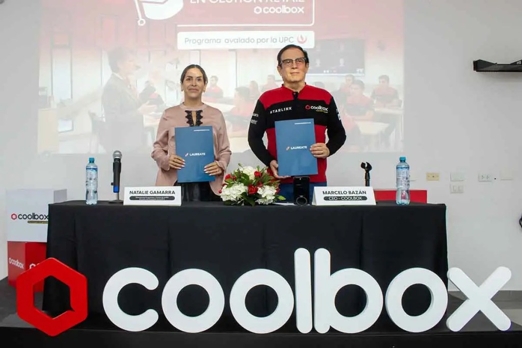 Natalie Gamarra y Marcelo Bazán sosteniendo documentos en un evento de coolbox, con una presentación en el fondo.
