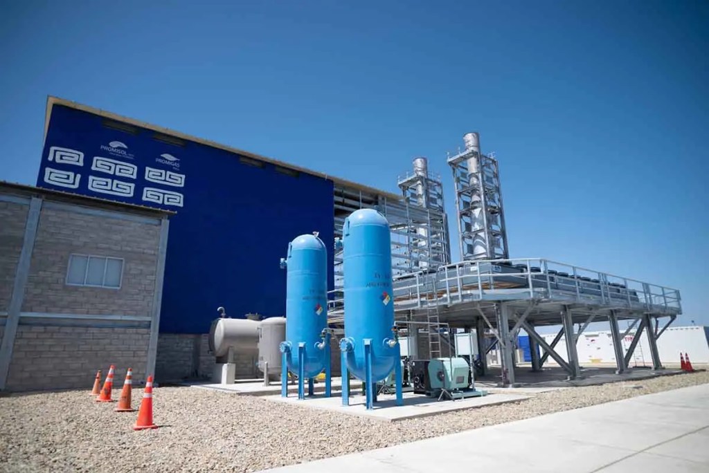 Planta industrial con tanques azules y estructura metálica, ubicada al aire libre, con cielo despejado.