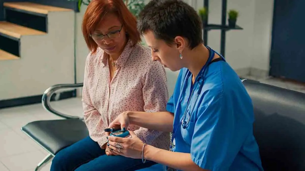 Una enfermera mostrando un dispositivo médico a una paciente en una clínica.